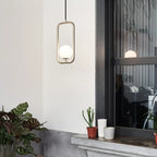 Rectangular Frame Opal Globe Pendant, beside a window with plants