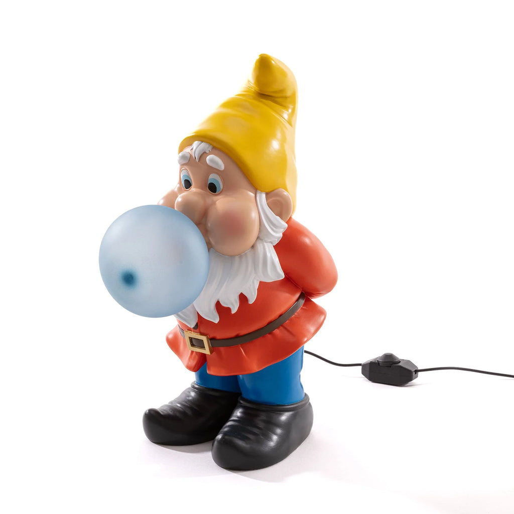 Resin dwarf table lamp blowing a glowing glass bubble, three-quarter view