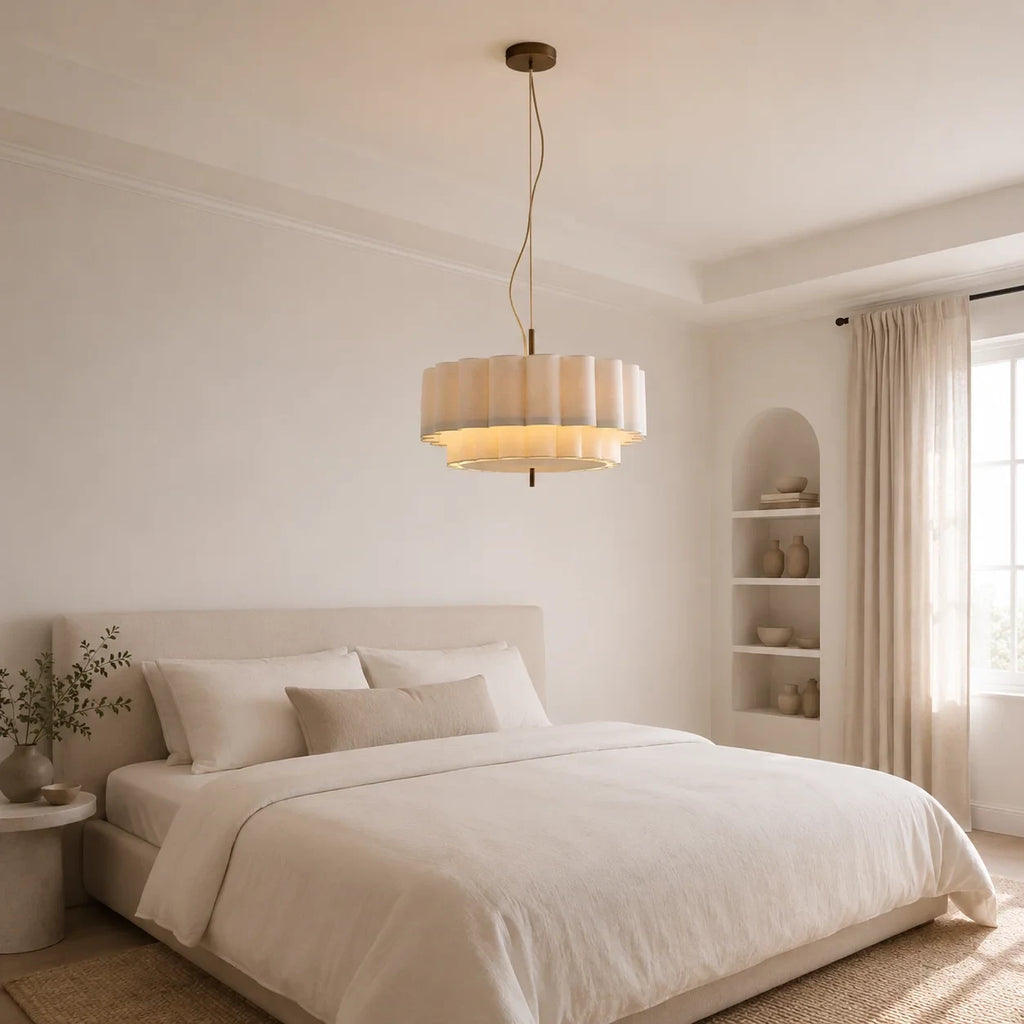 Layered ripple pendant light in white, above a bed