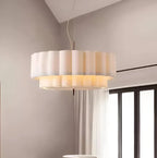 Layered ripple pendant light in white, in a living room by a window