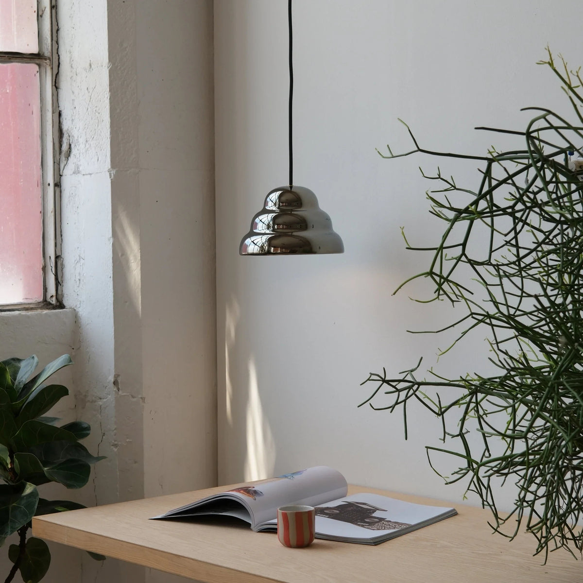 Rippled chrome-glaze stoneware pendant, above a desk by a window