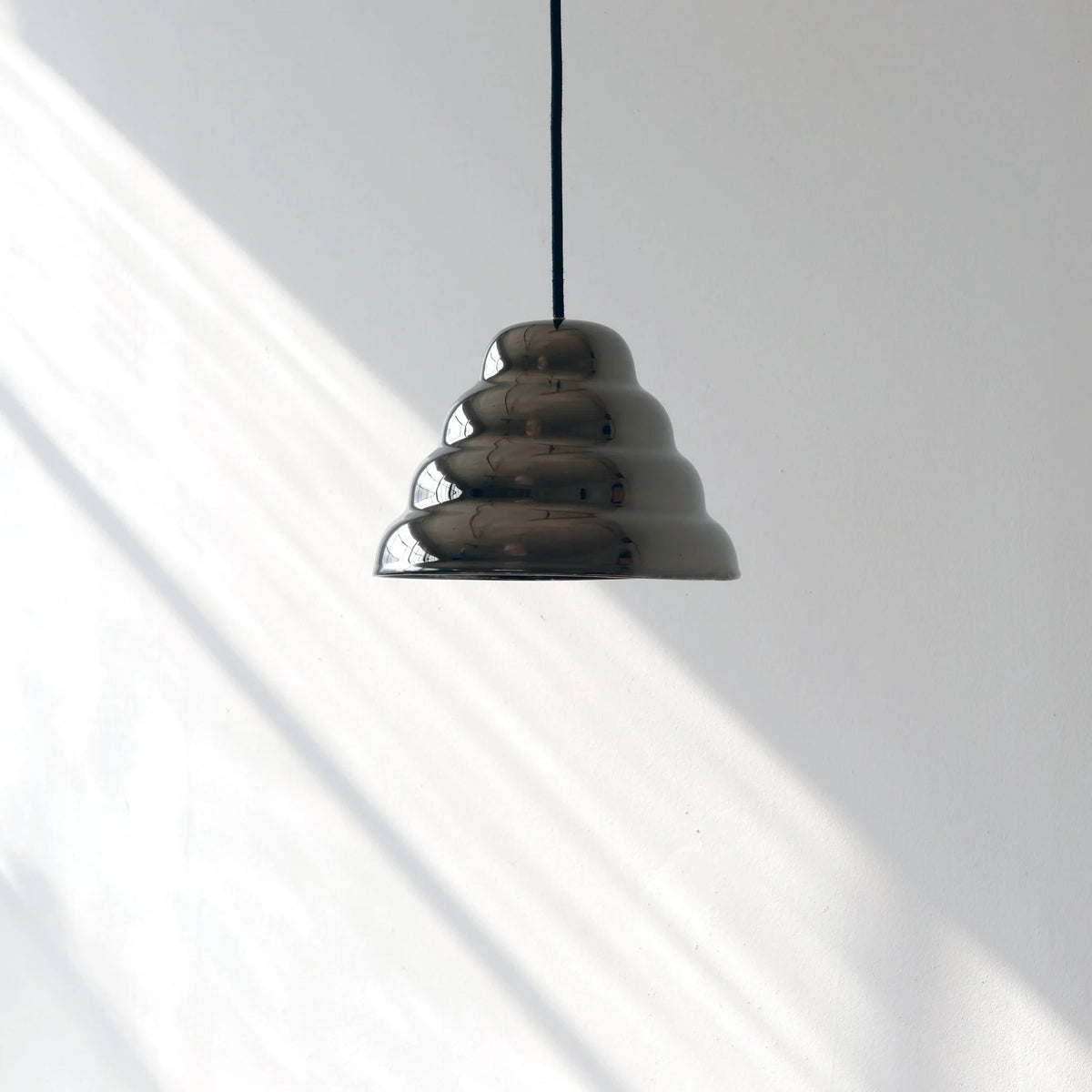 Rippled chrome-glaze stoneware pendant, in soft daylight