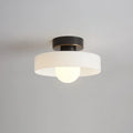 Round glass flush ceiling light, with a black base and white glass