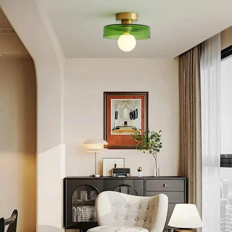Round glass flush ceiling light, with a gold base and green glass in a living room