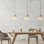 Sandblasted glass pendant, in all three finishes above a dining table