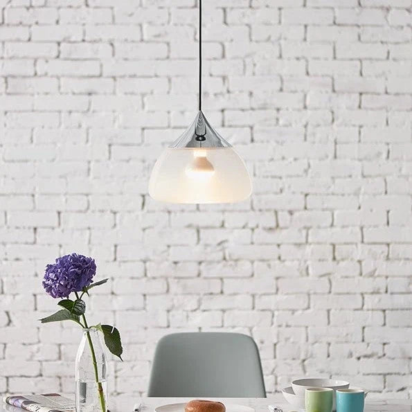 Sandblasted glass pendant, in chrome above a table