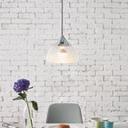 Sandblasted glass pendant, in chrome above a table