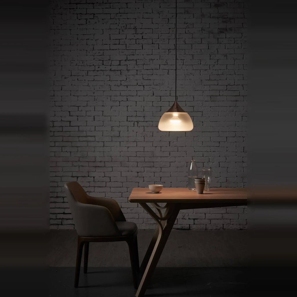 Sandblasted glass pendant, lit in a dark dining room