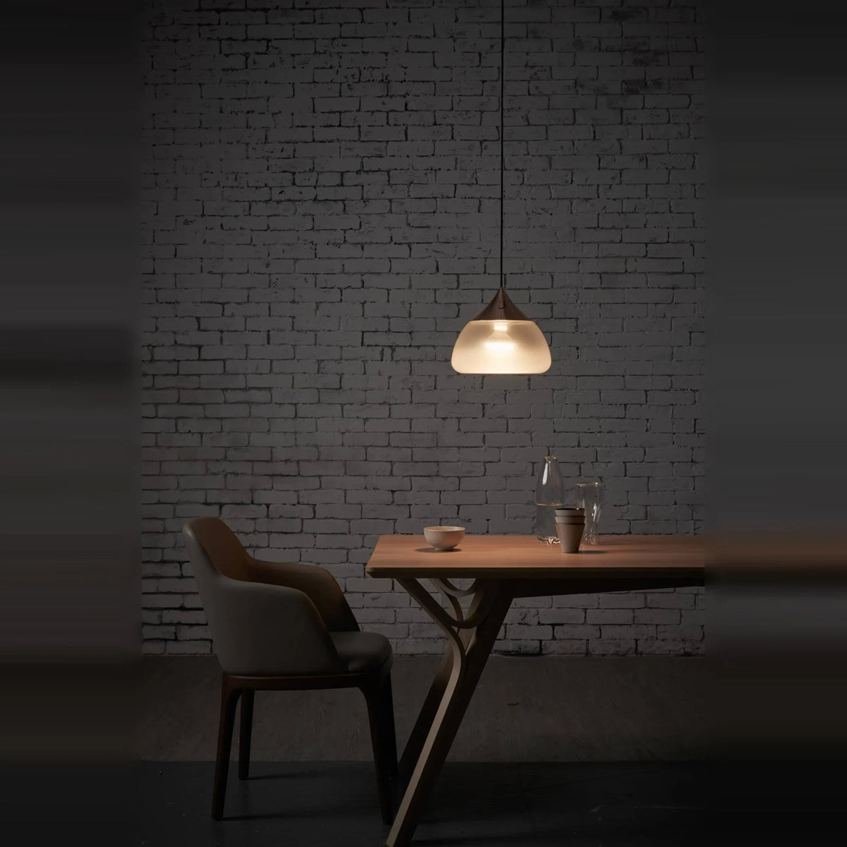 Sandblasted glass pendant, lit in a dark dining room
