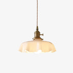 Scalloped cream glass pendant light with a brass fitting, on a white background
