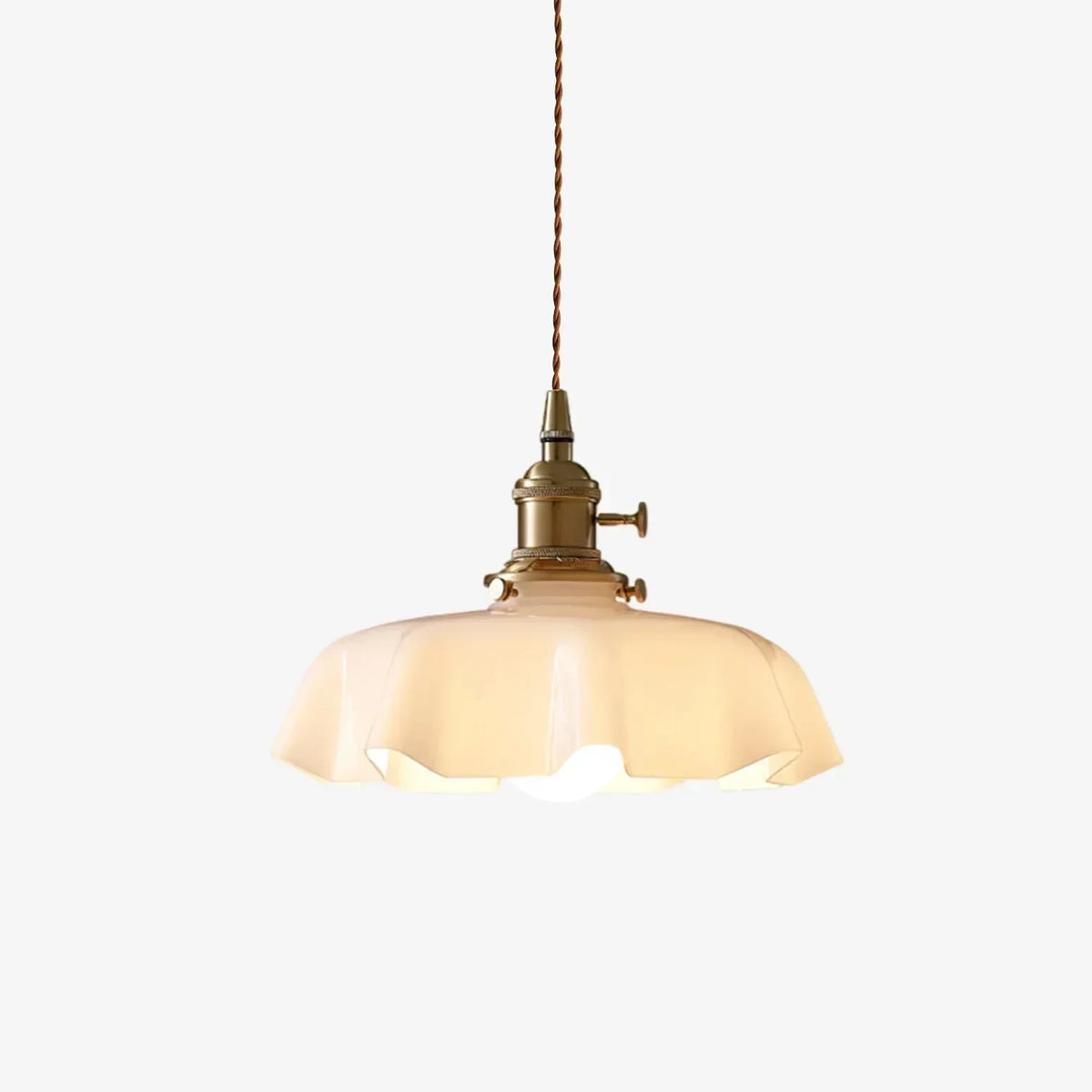 Scalloped cream glass pendant light with a brass fitting, on a white background