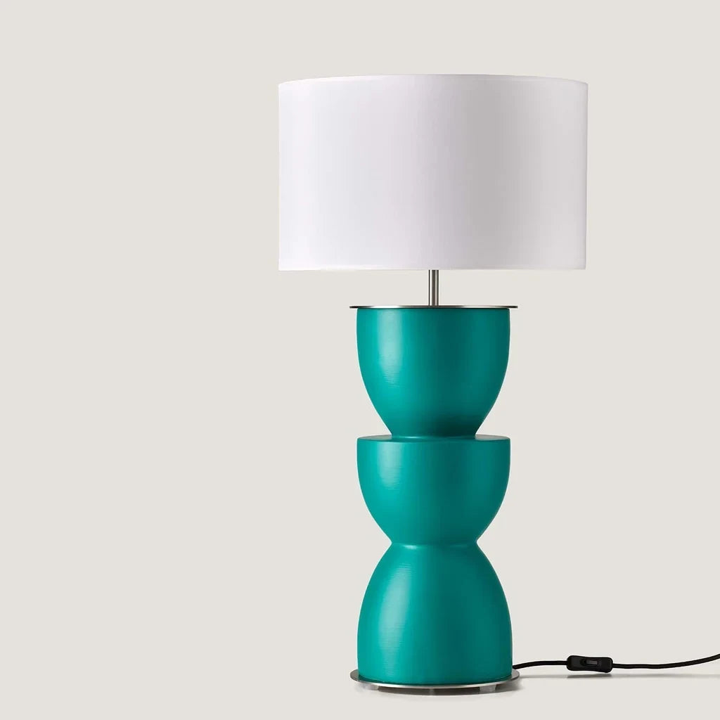 Sculpted stacked ceramic table lamp, in teal, on a plain background