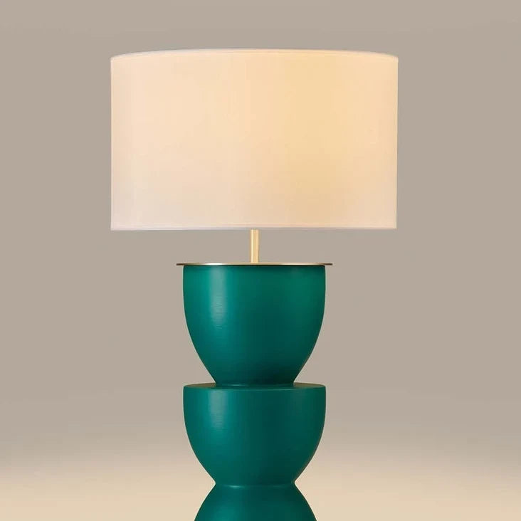Sculpted stacked ceramic table lamp, close-up of the teal body, lit
