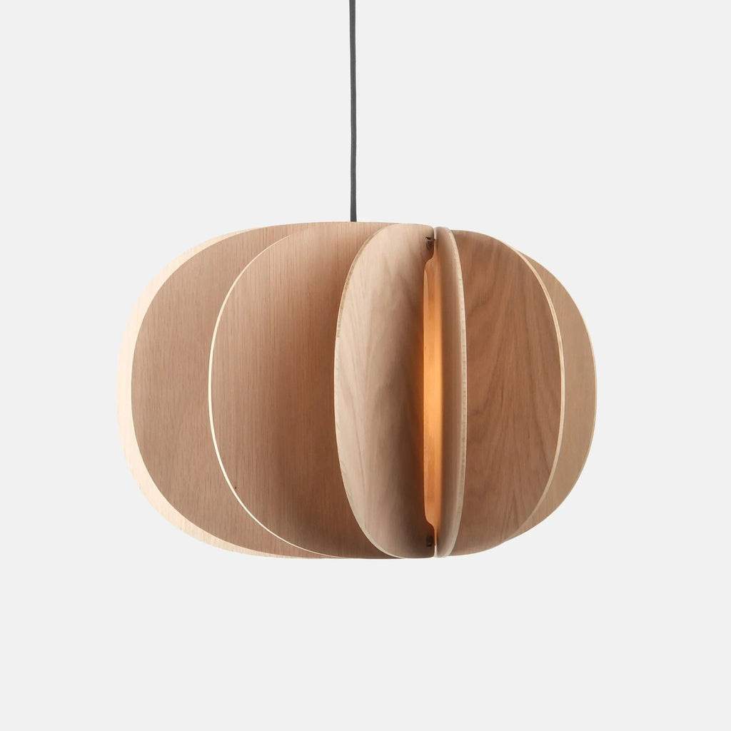 Sculptural white oak pendant, lit, on a plain background