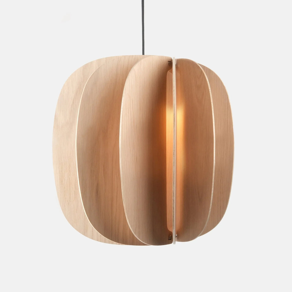 Sculptural white oak pendant, lit, on a plain background