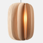 Sculptural white oak pendant, lit, on a plain background