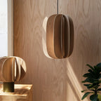 Sculptural white oak pendant, in a wood-panelled room
