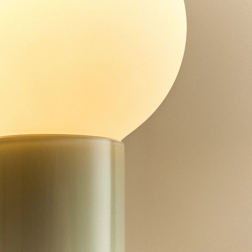 Mouth-blown glass table lamp in sea green, close-up of the glass base and bulb