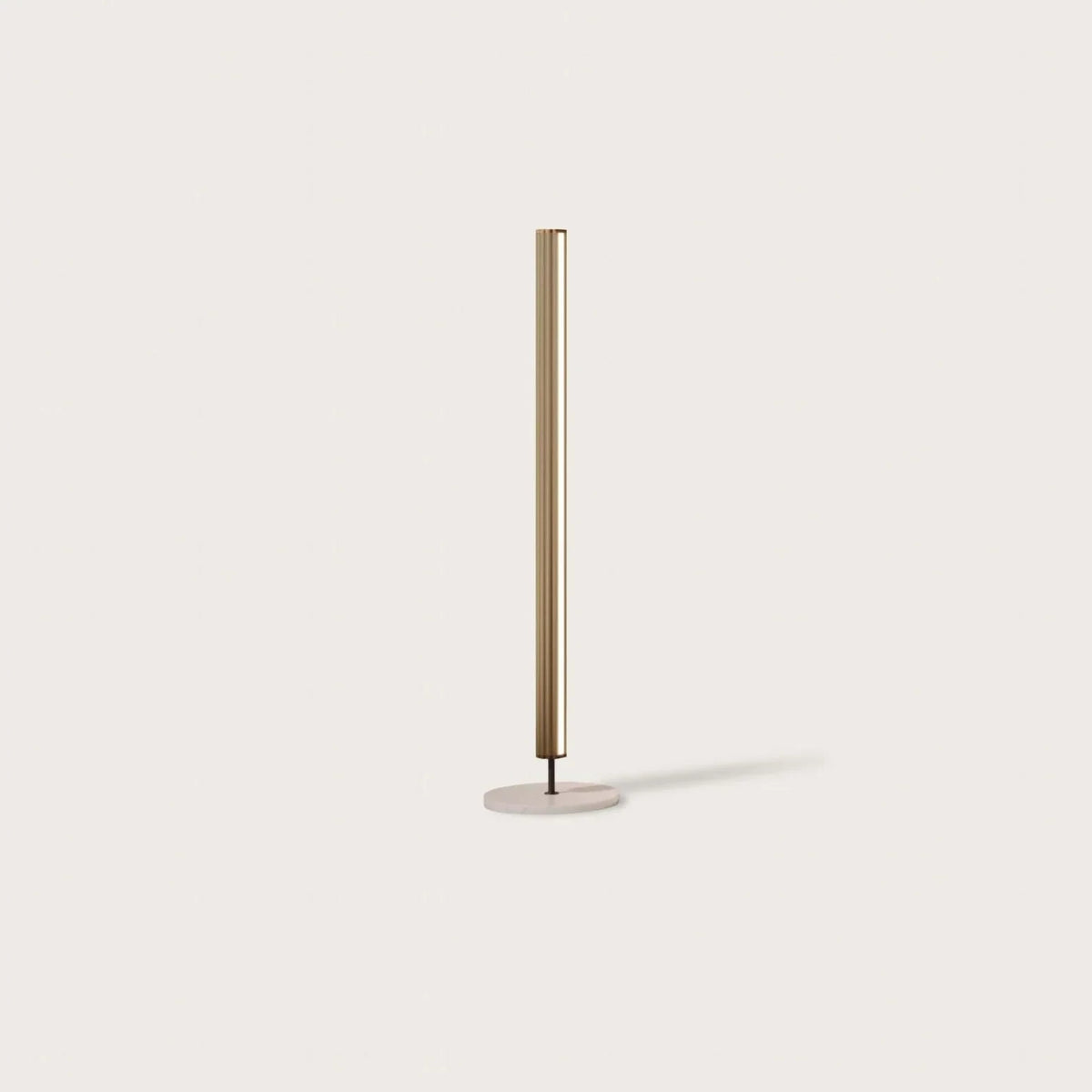 Slim LED column floor lamp with marble base, against a plain wall