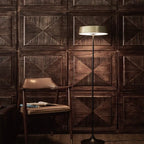 Slim disc LED floor lamp, in champagne gold beside a chair