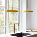 Slim disc LED pendant, 31cm, brass top, two in saffron yellow in a kitchen