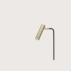 Slim reading floor lamp with small round head, close-up of the matte brass head