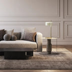 Slim stem table lamp with domed disc shade, in white, on a side table by a sofa