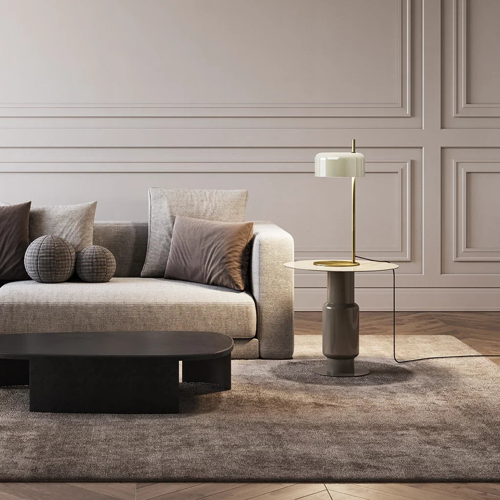 Slim stem table lamp with domed disc shade, in white, on a side table by a sofa