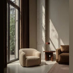 Slim stem table lamp with domed disc shade, in a lounge by a window