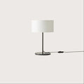 Slim stem table lamp base with black marble disc, with a black stem and a white drum shade (not included)
