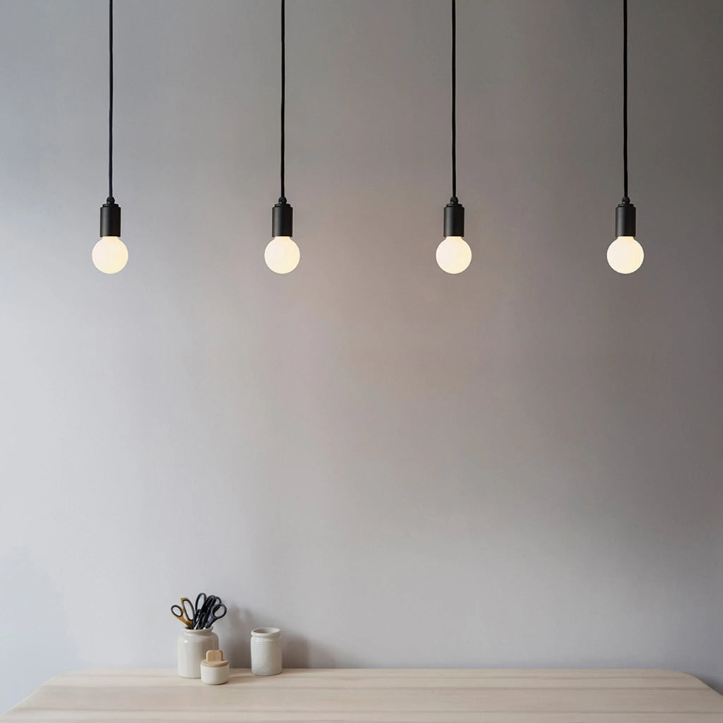 Small squat matte white glass pendant, graphite, four in a row above a table