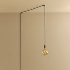 Plug-in pendant with small tinted bulb, graphite, lit, hung from a wall node
