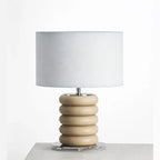 Stacked ceramic rings table lamp, in sand on a plinth, with a drum shade (not included)
