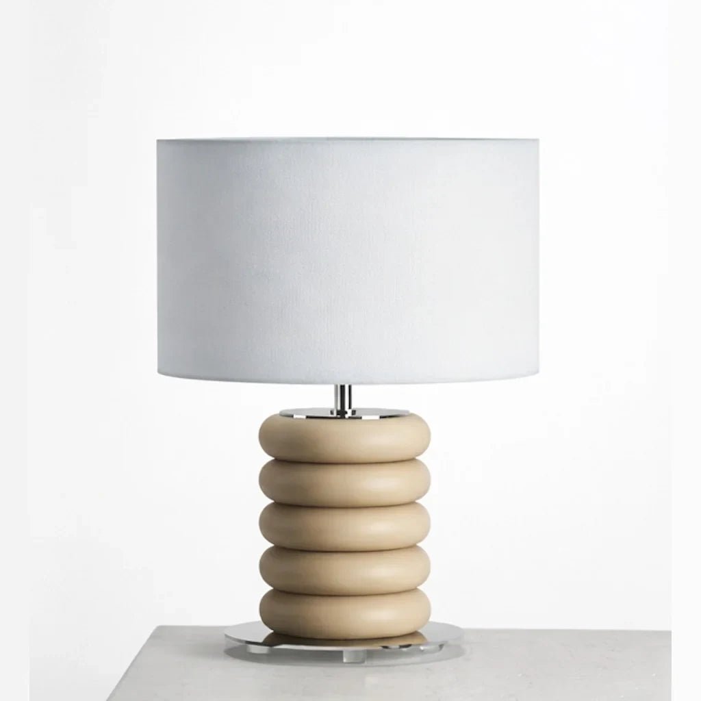 Stacked ceramic rings table lamp, in sand on a plinth, with a drum shade (not included)