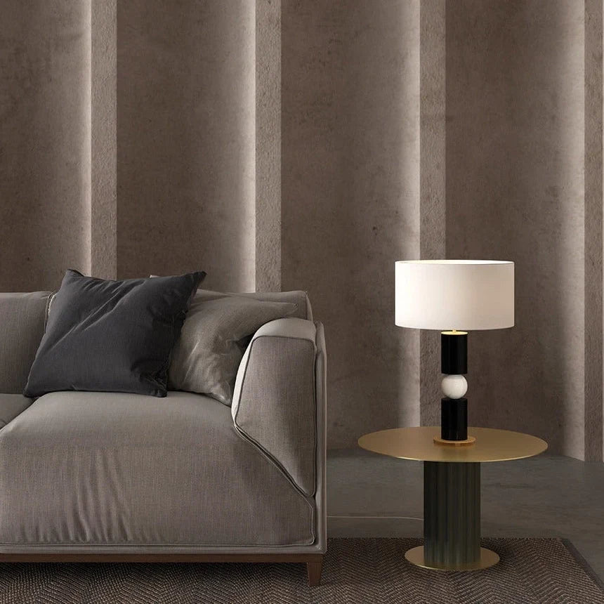 Stacked wood and marble sphere table lamp base, lit beside a sofa, with a shade (sold separately)