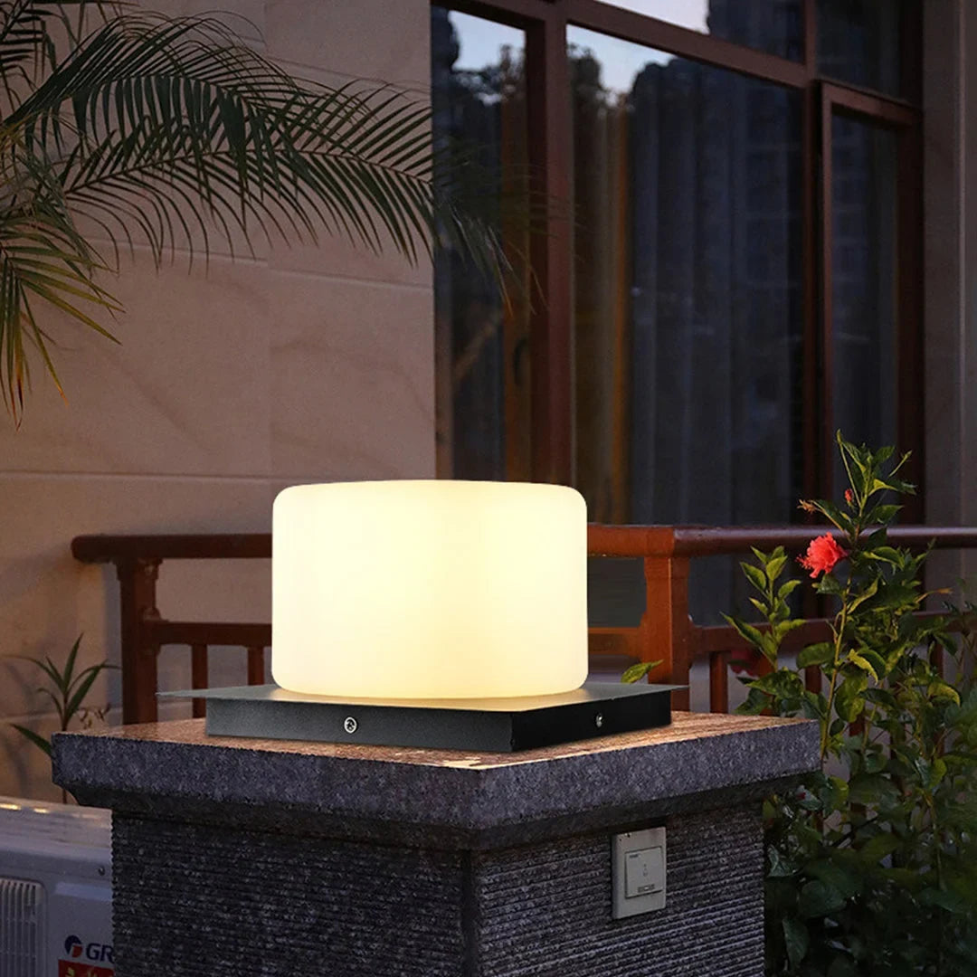 Outdoor pillar light, cylinder shade lit on a stone pillar