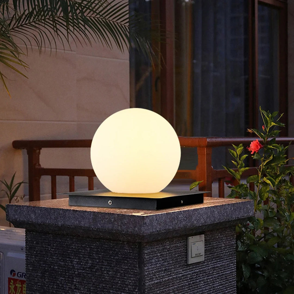 Outdoor pillar light, globe shade lit on a stone pillar