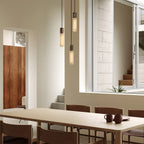 Three-drop cluster pendant in cast stainless steel with glass bulbs, over a dining table