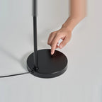 Slim desk table lamp with rotating shade, touching the dimmer on the base