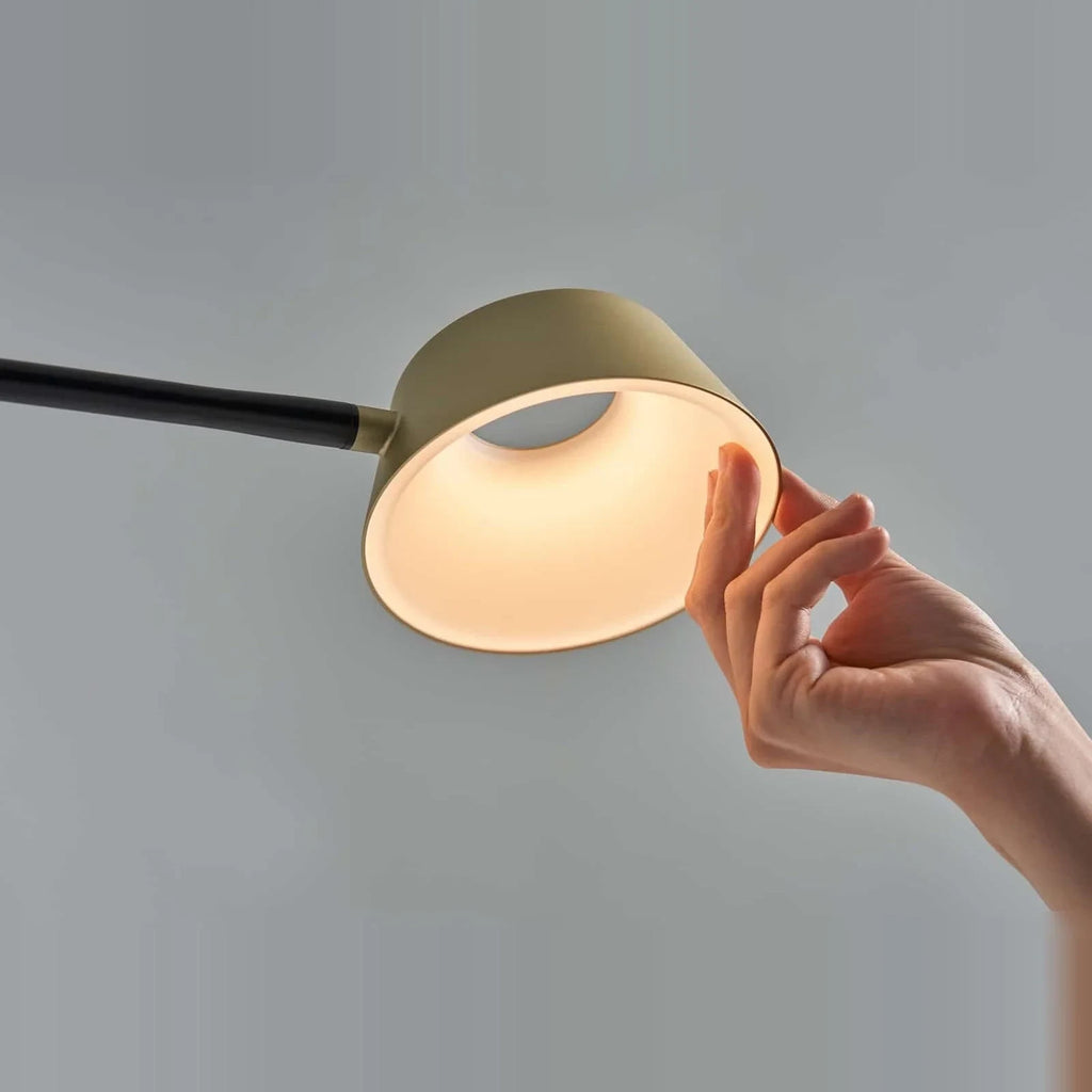 Slim desk table lamp with rotating shade, hand turning the shade