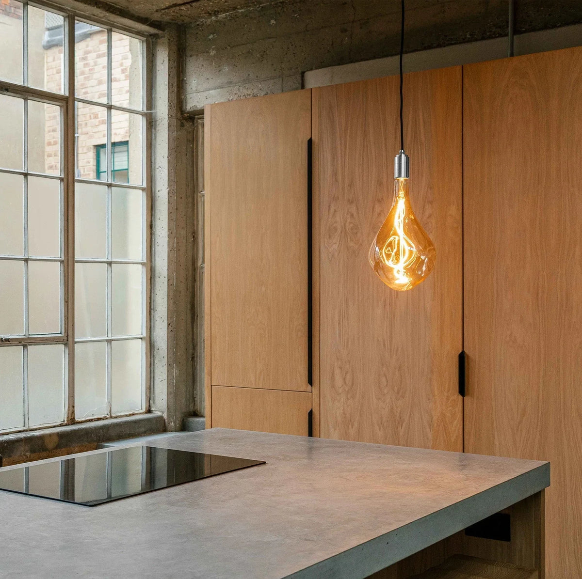 Tall tinted bulb plug-in pendant, above a kitchen worktop