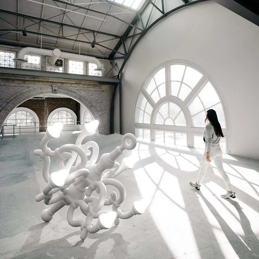 Tangled arm XL floor chandelier, in white in a large hall with a person for scale