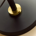 Brass telescopic floor lamp with a globe bulb, close-up of the round base and brass collar
