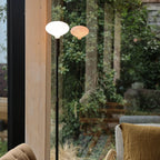 Graphite telescopic floor lamp, by a window onto a garden