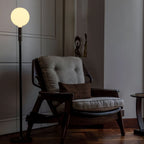 Graphite telescopic floor lamp, beside an armchair