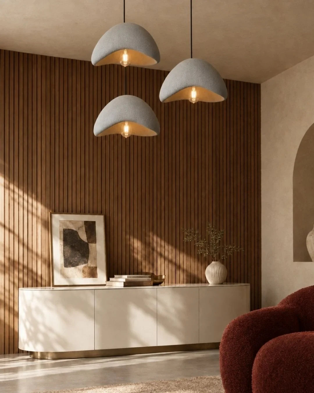 Textured sculptural pendant light, three in grey above a sideboard