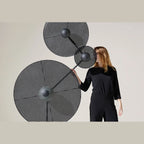 Three-holder floor lamp with angled arm, shown with optional discs (not included), with a person standing behind them