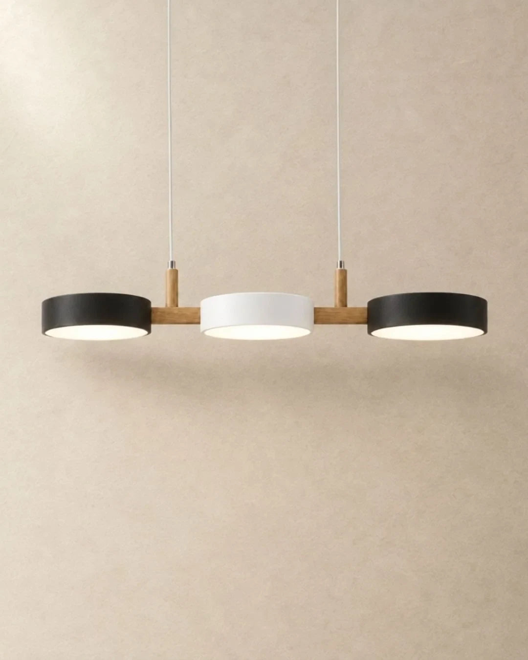 Three-light linear pendant with a wooden bar, with black, white and black shades