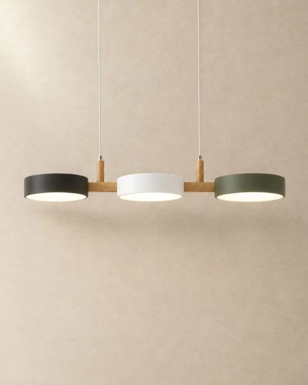 Three-light linear pendant with a wooden bar, with black, white and green shades