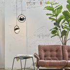 Tilting shade LED pendant in ring frame, two pendants beside a sofa